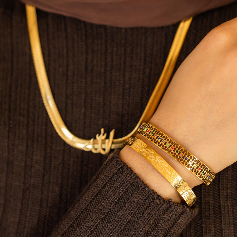 Gold necklace and bracelets on a brown textured background