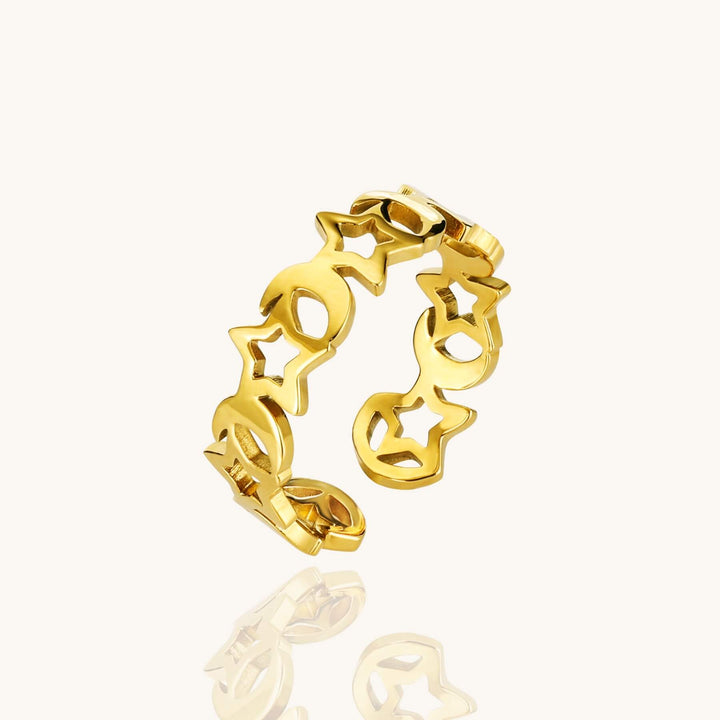 Gold ring with star and moon designs on a white background
