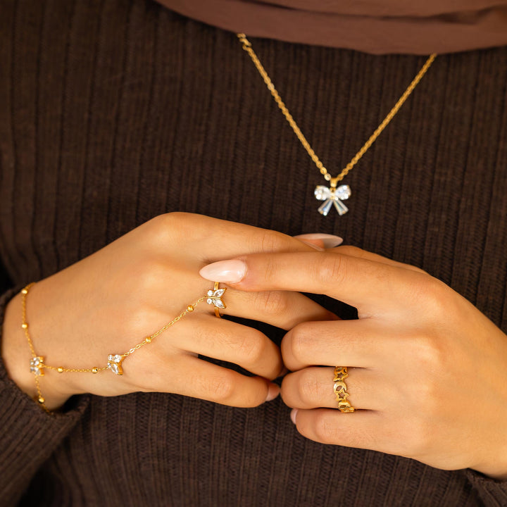 Close-up of hands wearing gold jewelry on a brown background