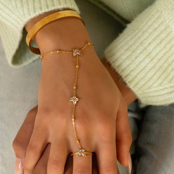 Gold bracelet and ring on a hand with a light green sweater
