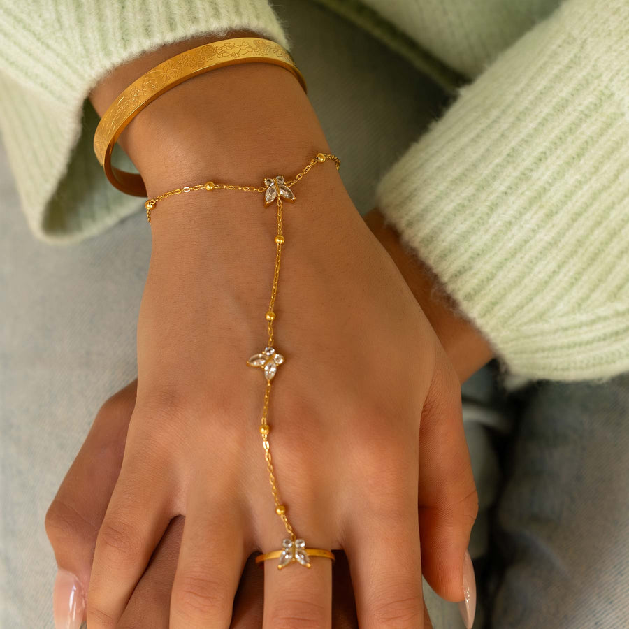 Gold bracelet and ring on a hand with a light green sweater