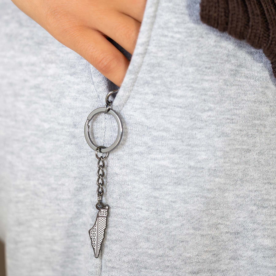 Palestine keychain worn on a gray hoodie